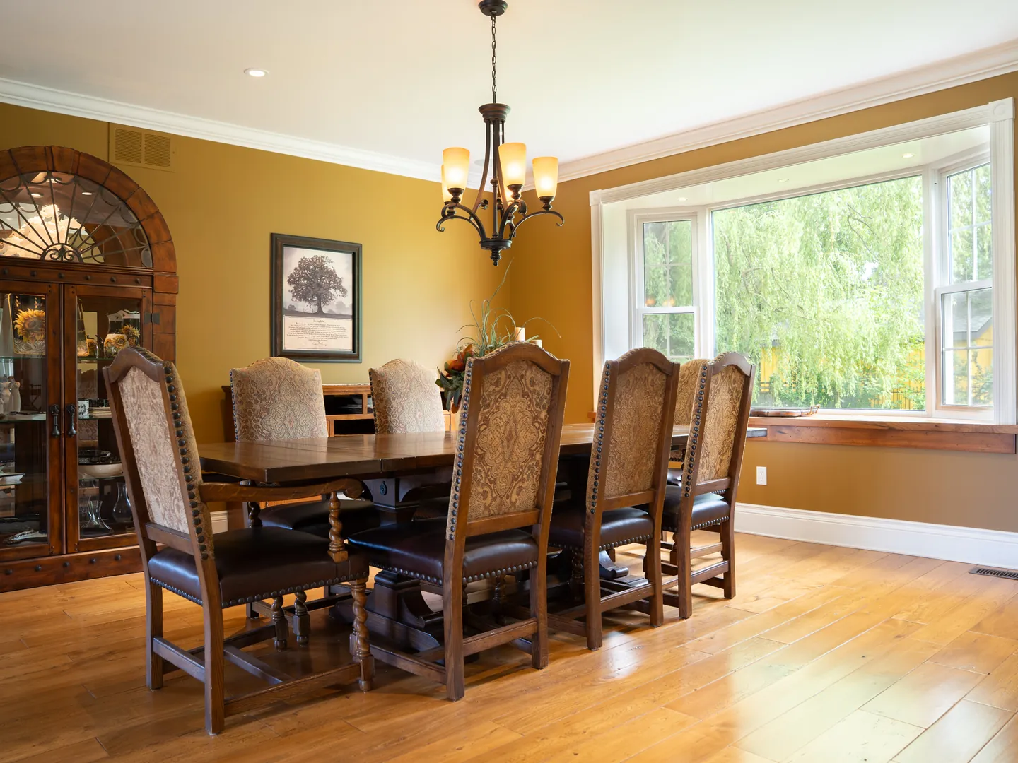 Dining room with hardwood floors and a bay window onto the lawn