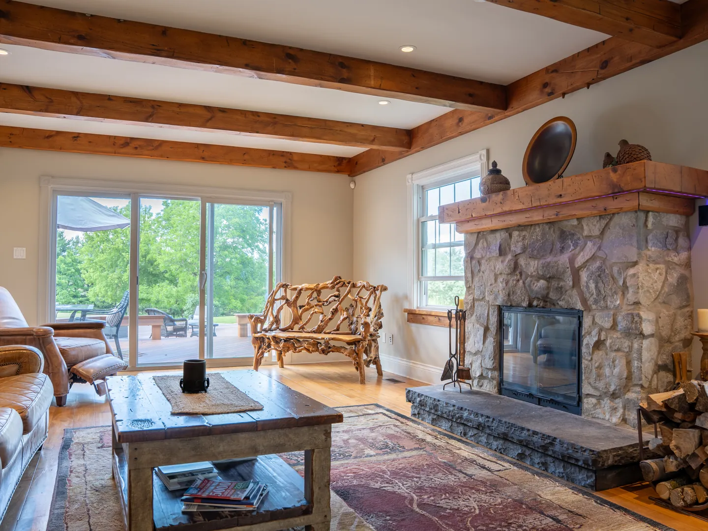 Living room with exposed beams and stone fireplace