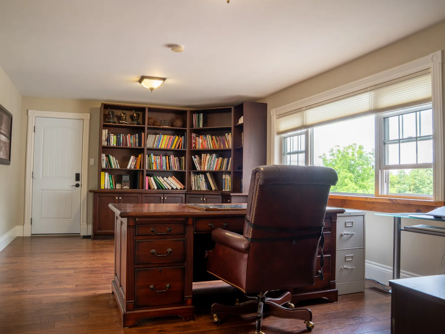 Home office with built-in book wall and dark wood desk