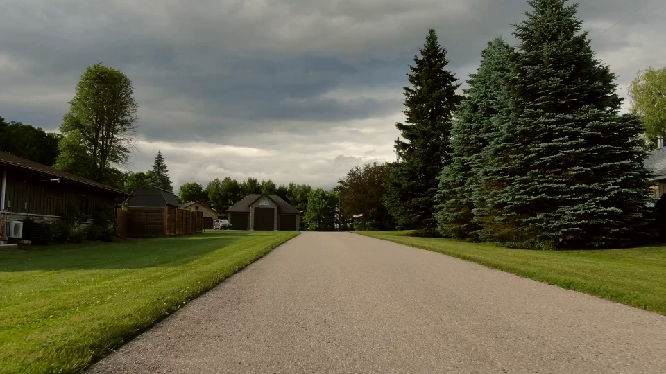 Aerial view along the driveway approaching the house and garage
