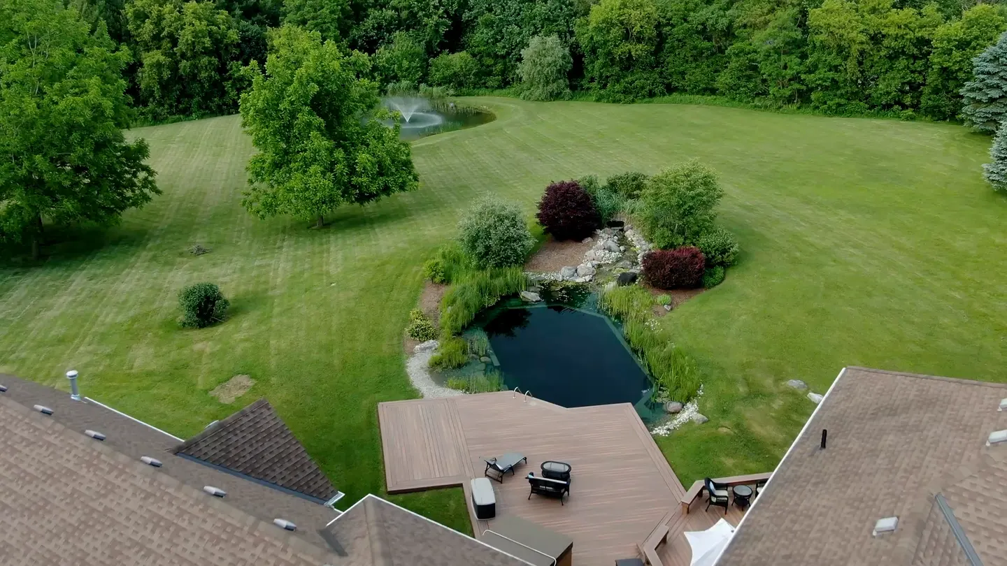 Aerial view descending toward the natural pool and rear deck